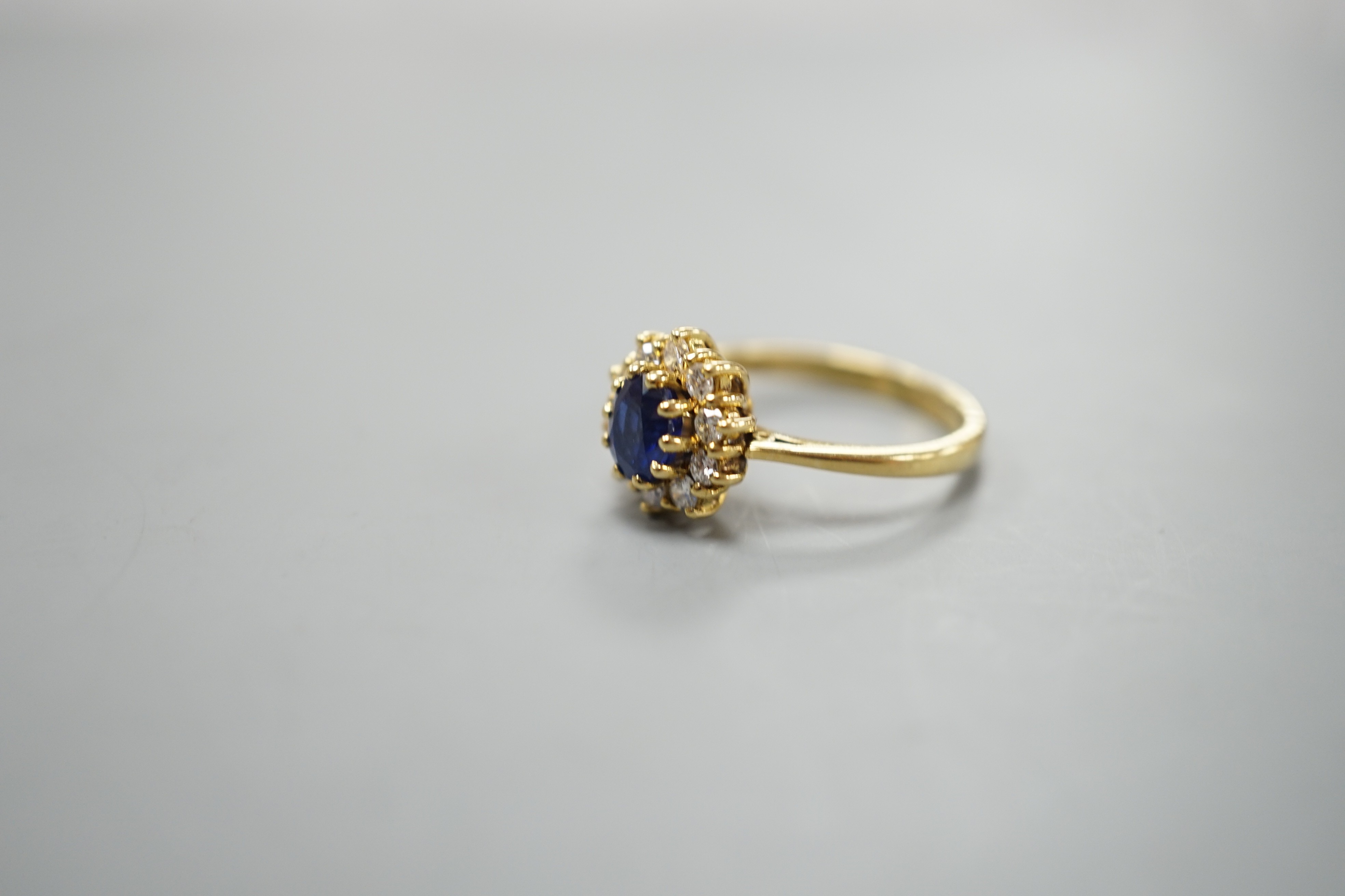 A modern 18ct gold, sapphire and diamond set oval cluster ring, size L, gross weight 3.8 grams